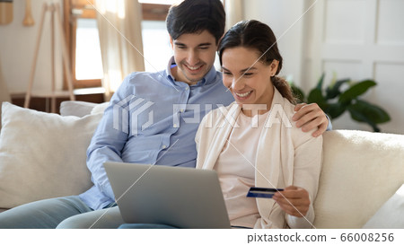 Happy couple shopping online on laptop using bankcard 66008256
