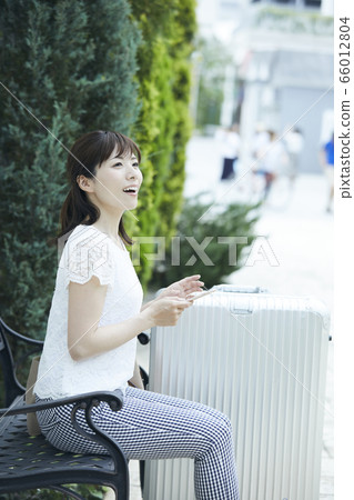 A young woman with a suitcase A young woman with a suitcase 66012804