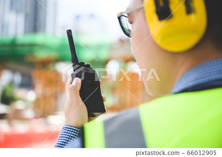 Young asian engineers are working on the construction site. Wear a yellow earmuff sound protection 66012905