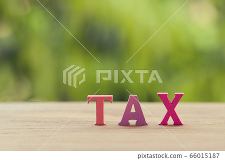Finance tax concept: Arrangement wooden letters word TAX on table. depicts ad valorem tax on the value of the property all legitimately Finance tax concept: Arrangement wooden letters word TAX on table. depicts ad valorem tax on the value of the property all legitimately 66015187