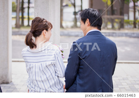 Asian couple proposing with a bouquet Asian couple proposing with a bouquet 66015463