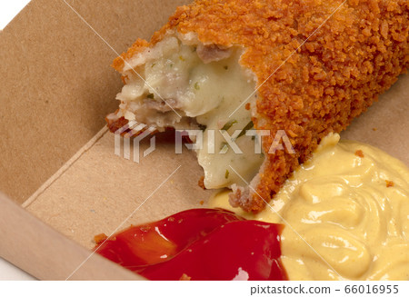 Partly eaten brown crusty dutch kroket with 66016955