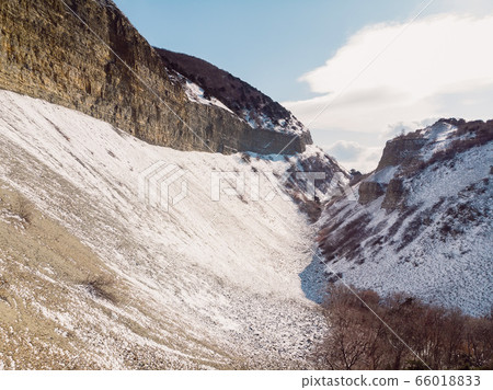 Canyon with snow in winter with sunlight, aerial drone view 66018833