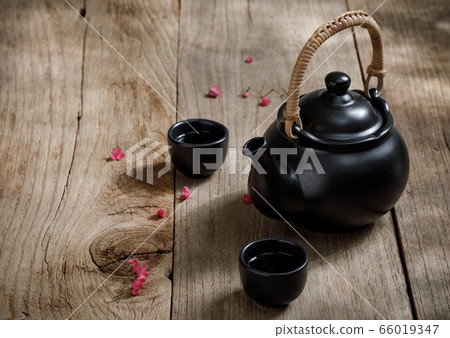 Cup of hot tea with steaming jugs on the woodCup of hot tea with steaming jugs on the wooden table background with copyspace for your text, Chinese styleen Cup of hot tea with steaming jugs on the woodCup of hot tea with steaming jugs on the wooden table background with copyspace for your text, Chinese styleen 66019347