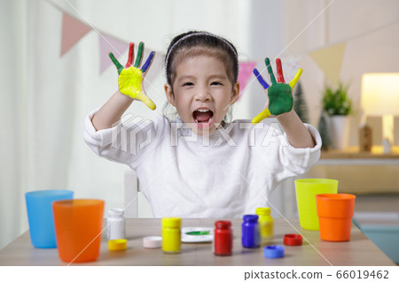 Kid's creativity, Child little asian girl hands painted in colorful paints in the class room at home, Educational concept for school Kid's creativity, Child little asian girl hands painted in colorful paints in the class room at home, Educational concept for school 66019462