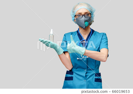 medical doctor nurse wearing protective mask - holding bottle of sanitizing spray or gel 66019653
