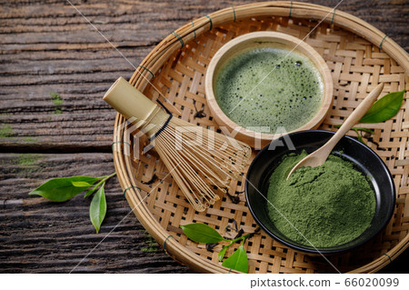 Japanese organic matcha green tea powder in bowl with wire whisk and green tea leaf on wooden background, Organic product from the nature for healthy with traditional style 66020099