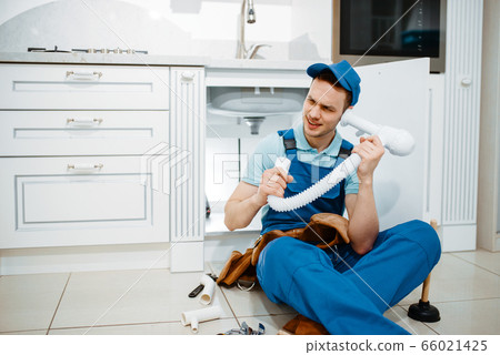 Male plumber listerns to the drain pipe, humor Male plumber listerns to the drain pipe, humor 66021425
