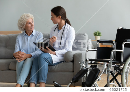 Doctor consulting disabled aged patient explain diagnosis during visit Doctor consulting disabled aged patient explain diagnosis during visit 66021725