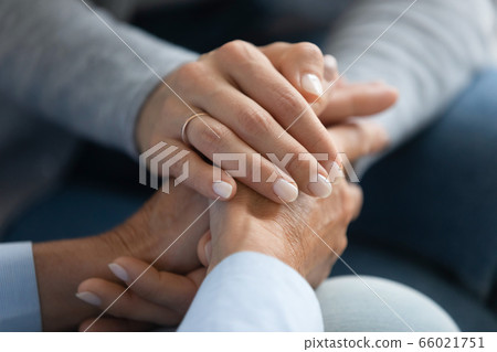 Adult daughter holding mothers hand close up image 66021751