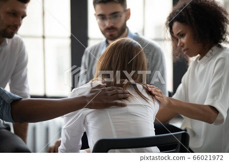Rear view diverse people supporting upset woman at therapy session 66021972