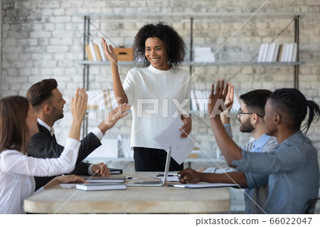 Smiling diverse business people raising hands, voting at corporate meeting Smiling diverse business people raising hands, voting at corporate meeting 66022047