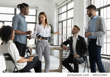 Confident businesswoman mentor leading briefing, teaching diverse employees Confident businesswoman mentor leading briefing, teaching diverse employees 66022064