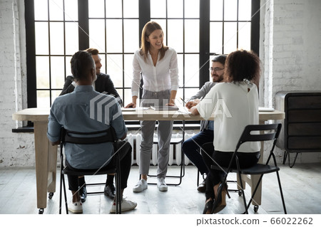 Smiling confident businesswoman team leader holding corporate briefing Smiling confident businesswoman team leader holding corporate briefing 66022262
