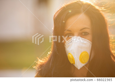 Woman in city with a face mask against infection 66022365