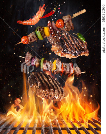 Tasty beef steaks and skewers flying above cast Tasty beef steaks and skewers flying above cast 66022366