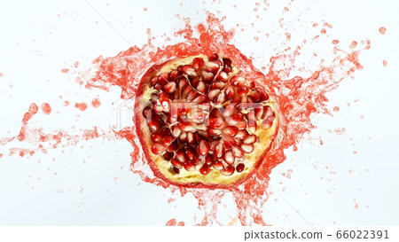 Freeze motion of sliced pomegranate with splashing 66022391