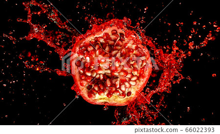 Freeze motion of sliced pomegranate with splashing 66022393