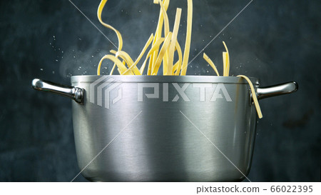 Throwing pasta into boiled water 66022395