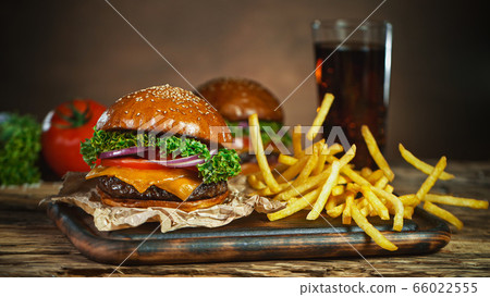 French fries fall next to cheeseburger, lying on French fries fall next to cheeseburger, lying on 66022555