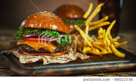 French fries fall next to cheeseburger, lying on French fries fall next to cheeseburger, lying on 66022556