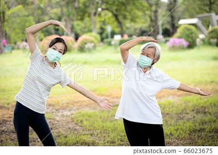Happy child girl is doing exercise activity for the old elderly,healthy senior woman workout and wear face mask outside home after Coronavirus quarantine or Covid-19 lockdown,work out for health care Happy child girl is doing exercise activity for the old elderly,healthy senior woman workout and wear face mask outside home after Coronavirus quarantine or Covid-19 lockdown,work out for health care 66023675