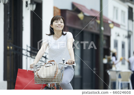 Woman riding a bicycle 66024608