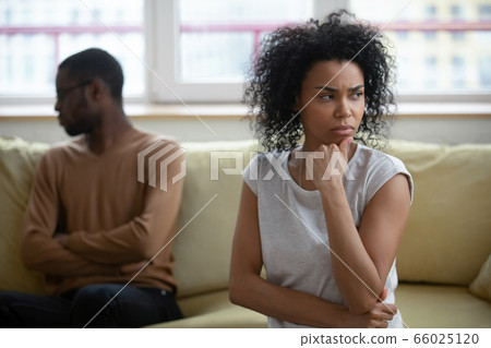African couple sitting apart thinking about relations problems African couple sitting apart thinking about relations problems 66025120