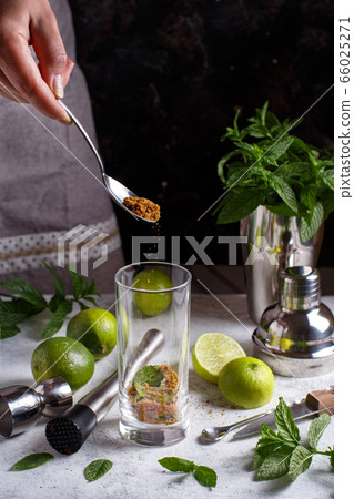 Sifting sugar in a homemade refreshing mojito 66025271