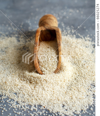 Raw uncooked fonio seeds with a spoon grey 66025274