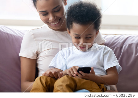 Son sit on mothers lap using smartphone play games Son sit on mothers lap using smartphone play games 66025299