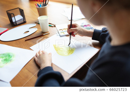 Girl drawing with paints and pencils at home, watching teacher's tutorial on laptop. Digitalization, remote education 66025723