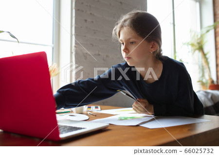 Girl drawing with paints and pencils at home, watching teacher's tutorial on laptop. Digitalization, remote education 66025732