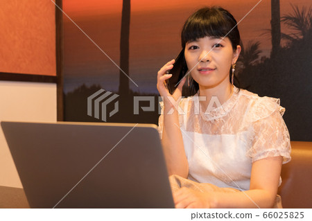 女人用一台筆記本電腦打電話 女人用一台筆記本電腦打電話 66025825