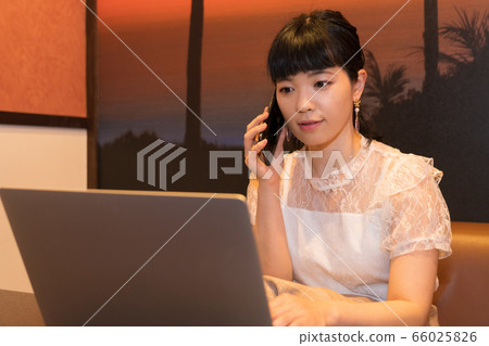 女人用一台筆記本電腦打電話 女人用一台筆記本電腦打電話 66025826