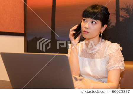 女人用一台筆記本電腦打電話 女人用一台筆記本電腦打電話 66025827