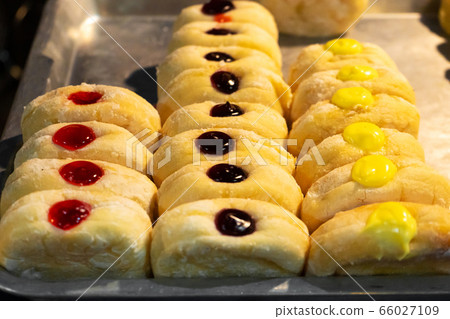 A showcase with pastries, rolls with colored 66027109