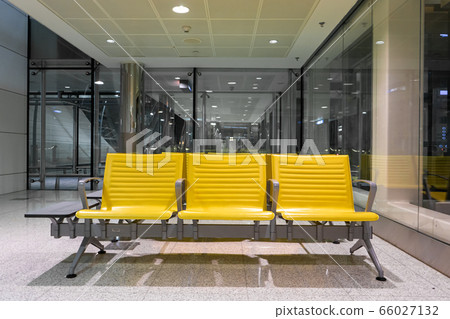 Rows of yellow benches in a waiting area at the Rows of yellow benches in a waiting area at the 66027132