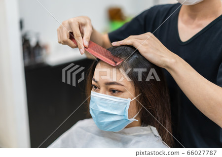 hairdresser cutting the hair to female client, 66027787