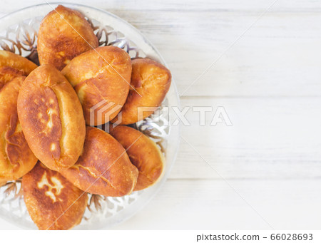 Piroshki - russian baked puff pastry with cabbage fillings. Traditional russian cabbage stuffed baked pastry. lean pies with cabbage. Beautiful homemade cakes with cabbage in metal dishes on white 66028693