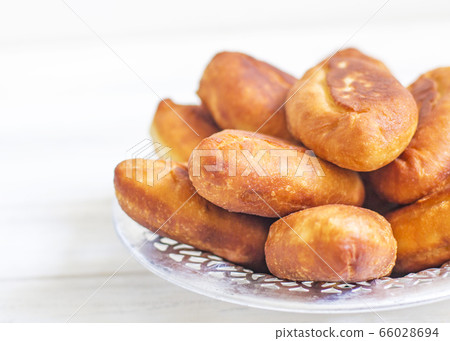 Piroshki - russian baked puff pastry with cabbage fillings. Traditional russian cabbage stuffed baked pastry. lean pies with cabbage. Beautiful homemade cakes with cabbage in metal dishes on white 66028694