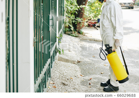 Worker disinfecting fence 66029688