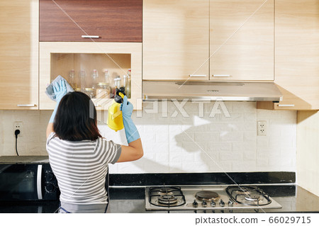 Woman cleaning kitchen cabinets Woman cleaning kitchen cabinets 66029715
