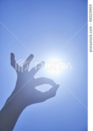 Young woman reaching for the blue sky 66029904