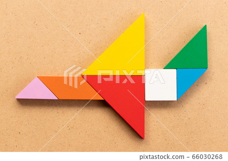 Color tangram puzzle in airplane shape on wood background Color tangram puzzle in airplane shape on wood background 66030268
