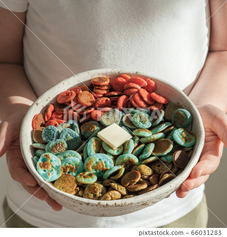 Colorful pancake cereal in baby hands 66031283