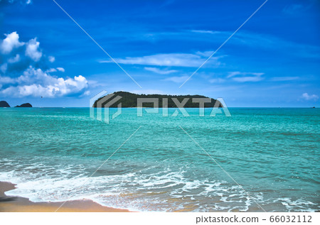 Waves of the azure Andaman sea under the blue sky reaching the shores of the sandy beautiful exotic and stunning Cenang beach in Langkawi island, in Malaysia Waves of the azure Andaman sea under the blue sky reaching the shores of the sandy beautiful exotic and stunning Cenang beach in Langkawi island, in Malaysia 66032112