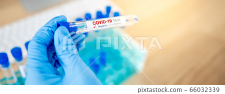 Medical scientist holding COVID-19 test tube 66032339