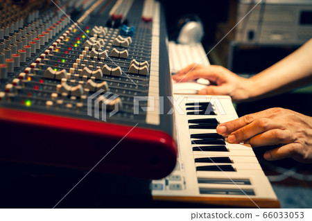 music composer hands playing on piano keys in recording studio 66033053