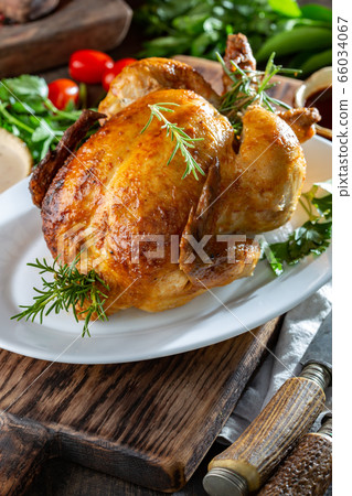 Whole Roasted Chicken on white plate with rosemary, sauces and vegetables Whole Roasted Chicken on white plate with rosemary, sauces and vegetables 66034067